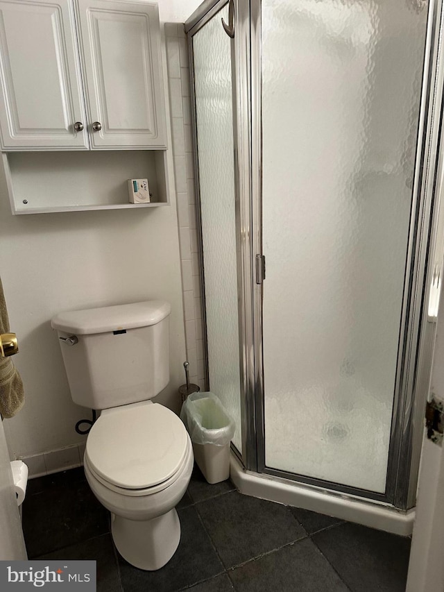 bathroom with toilet, an enclosed shower, and tile patterned flooring