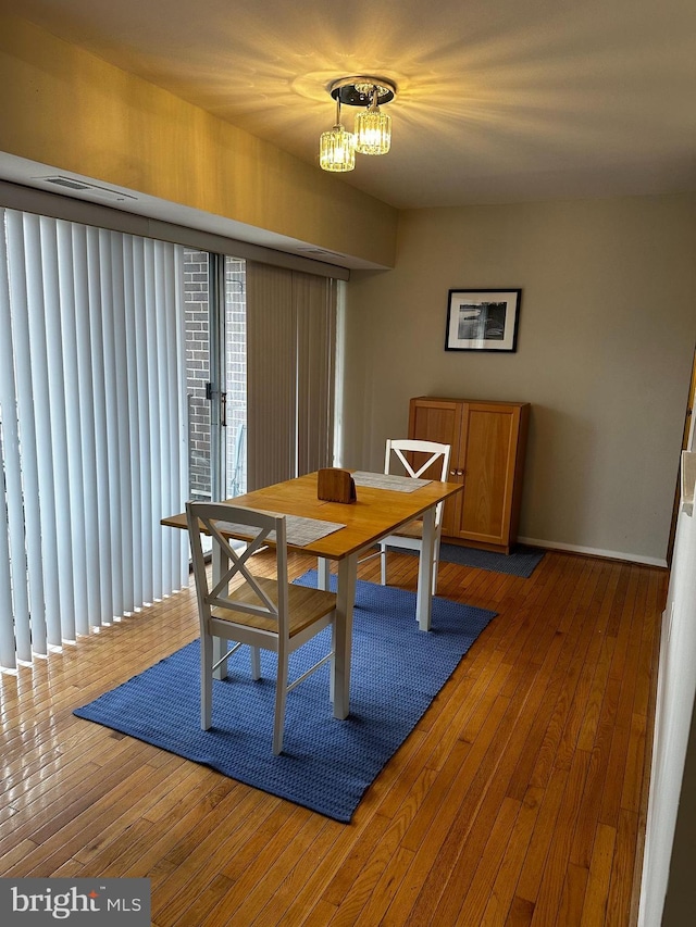 dining space with dark wood-type flooring and a notable chandelier