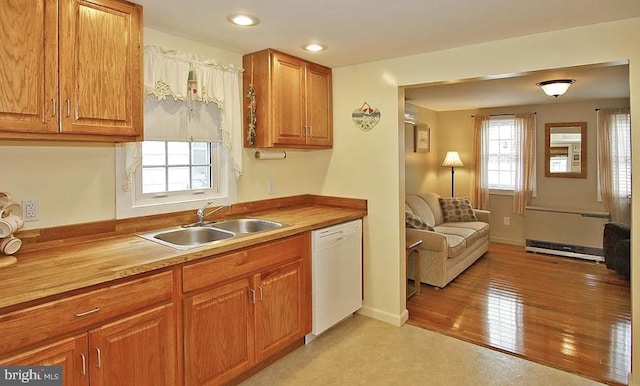 kitchen featuring a baseboard radiator, sink, white dishwasher, and light wood-type flooring