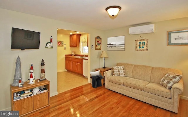 living room featuring sink, a wall mounted AC, and light hardwood / wood-style flooring