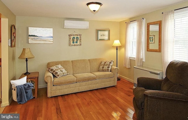 living room featuring hardwood / wood-style flooring, plenty of natural light, and a wall mounted AC