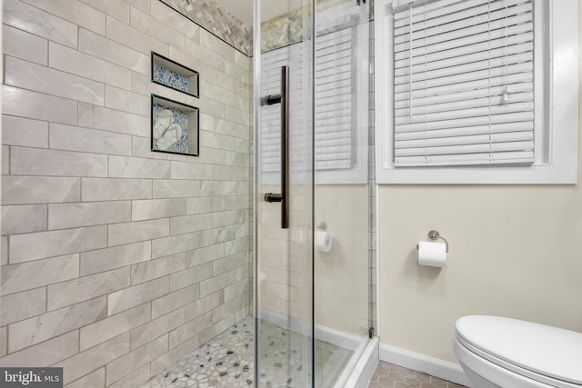 bathroom with an enclosed shower and toilet