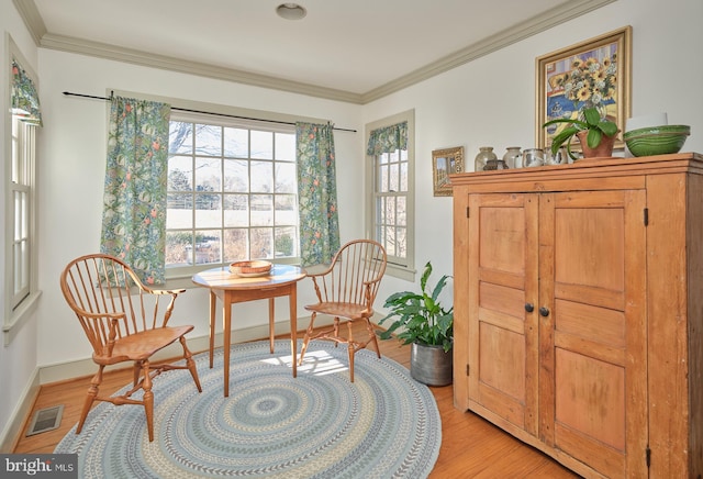 living area featuring crown molding and light wood-type flooring