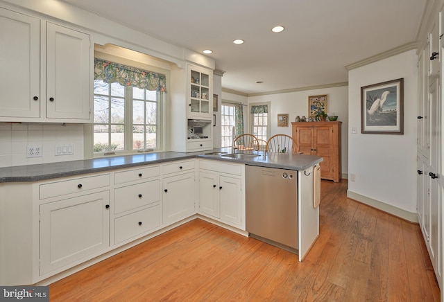 kitchen featuring white cabinetry, stainless steel dishwasher, ornamental molding, kitchen peninsula, and light hardwood / wood-style floors