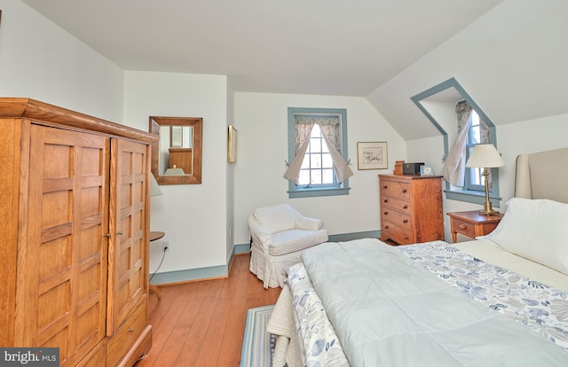 bedroom with vaulted ceiling and light hardwood / wood-style floors