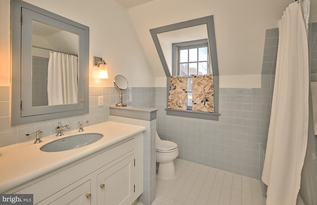 bathroom featuring toilet, a shower with curtain, tile walls, vanity, and tile patterned flooring