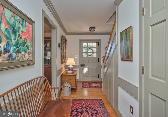 entryway with crown molding and light hardwood / wood-style floors