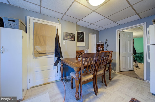 dining area featuring a drop ceiling