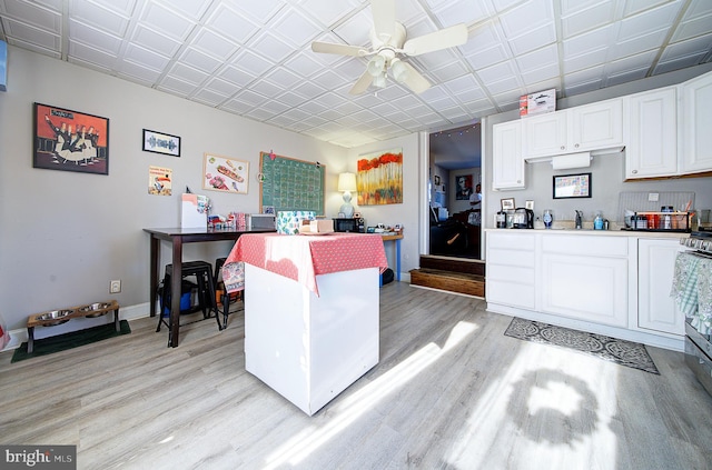 kitchen featuring white cabinetry, sink, ceiling fan, and light hardwood / wood-style floors