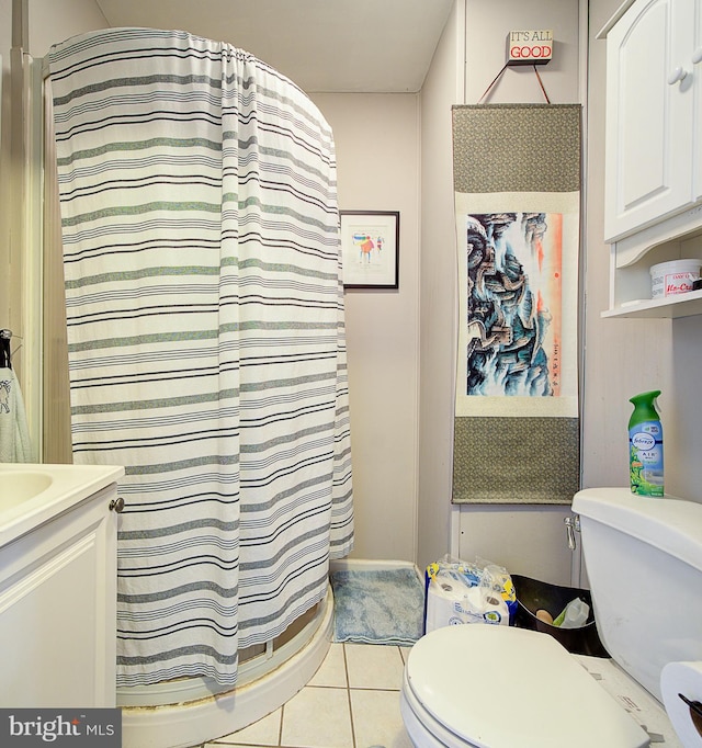 bathroom with vanity, curtained shower, tile patterned floors, and toilet