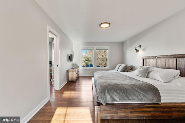 bedroom featuring baseboards and dark wood-type flooring