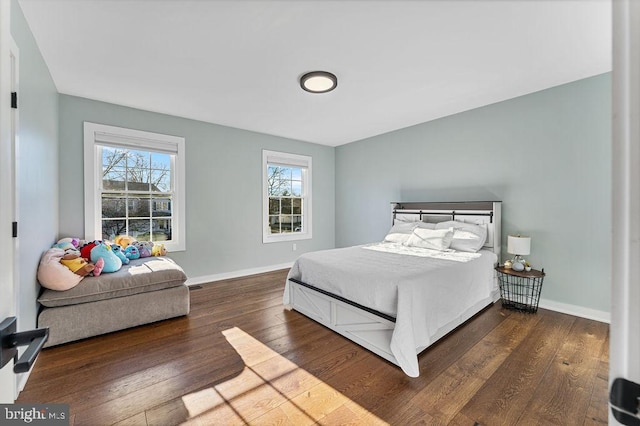 bedroom with baseboards and dark wood-style flooring