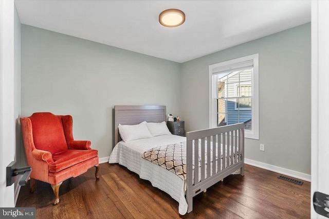 bedroom with baseboards, visible vents, and dark wood finished floors