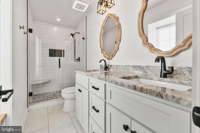 bathroom with a sink, double vanity, toilet, and a stall shower