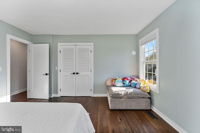 bedroom featuring baseboards, a closet, dark wood-style floors, and visible vents