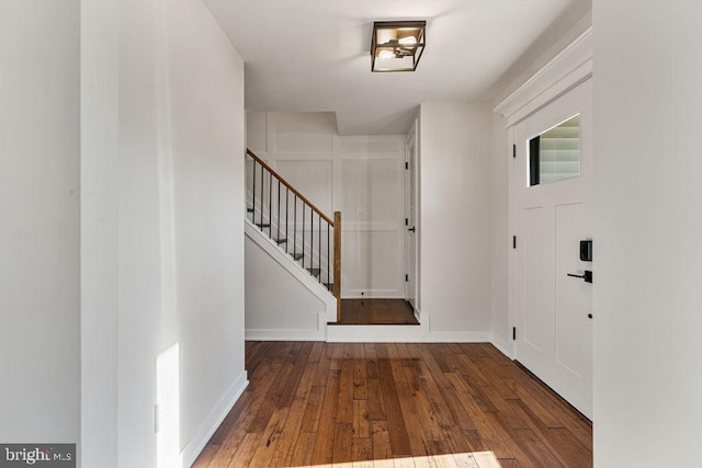 entrance foyer with baseboards, stairway, and wood finished floors