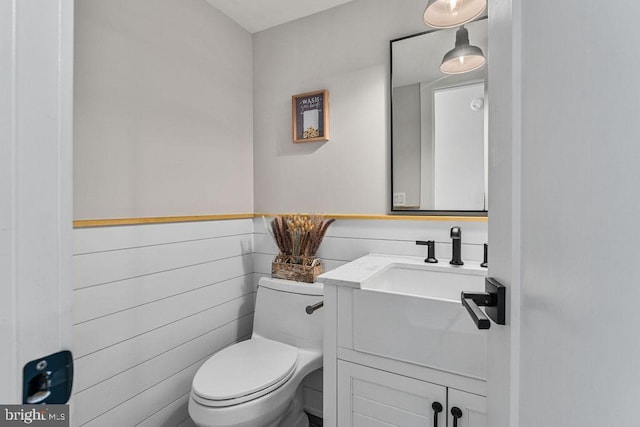 bathroom featuring wainscoting, vanity, and toilet