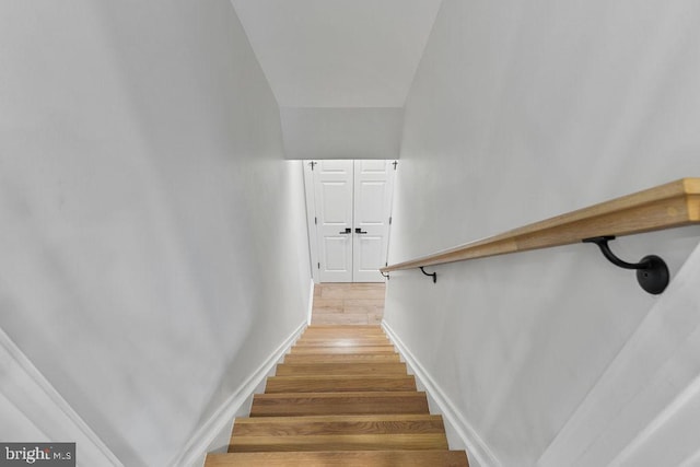 stairway featuring baseboards and wood finished floors