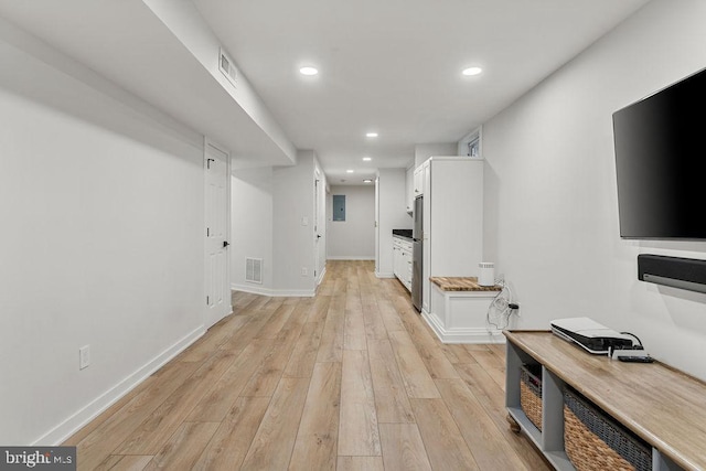 corridor with light wood-style flooring, baseboards, visible vents, and recessed lighting