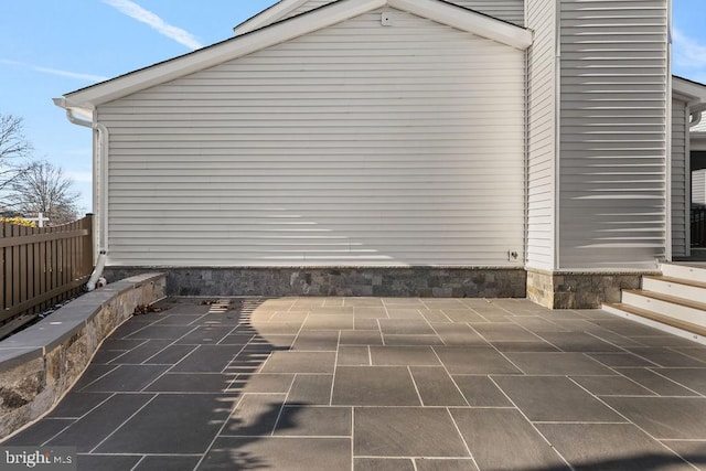 view of side of home with a patio area and fence