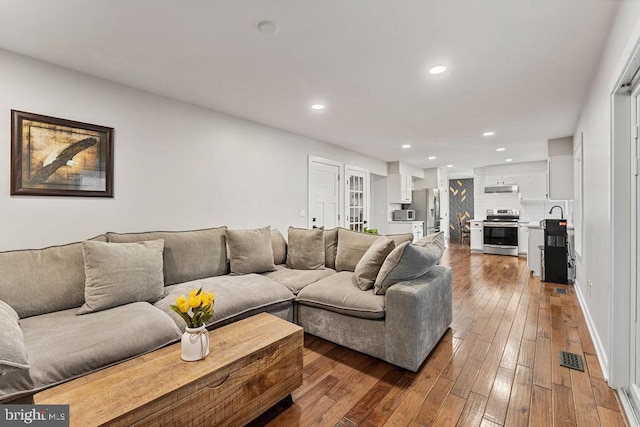 living room featuring visible vents, dark wood-type flooring, and recessed lighting