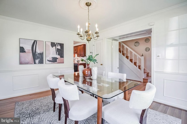 dining room featuring crown molding, wood-type flooring, and a chandelier