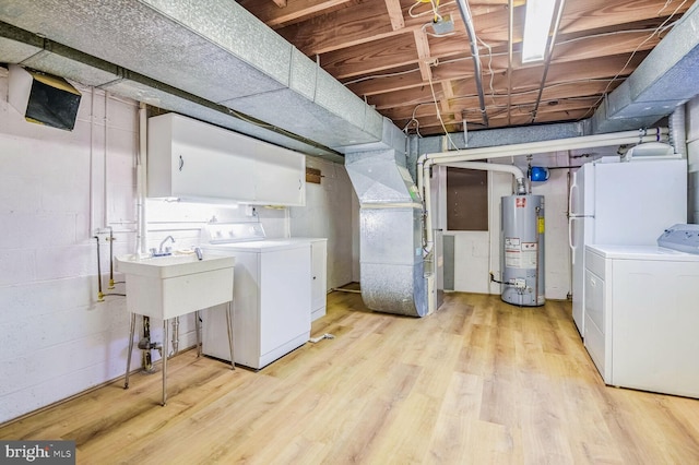 basement featuring sink, washer and clothes dryer, light hardwood / wood-style flooring, heating unit, and gas water heater