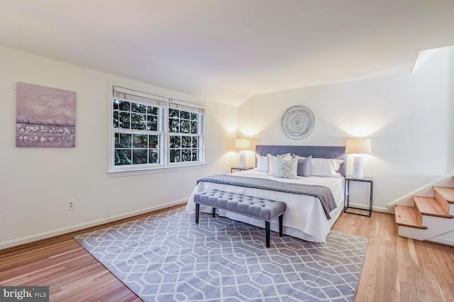 bedroom featuring wood-type flooring and vaulted ceiling