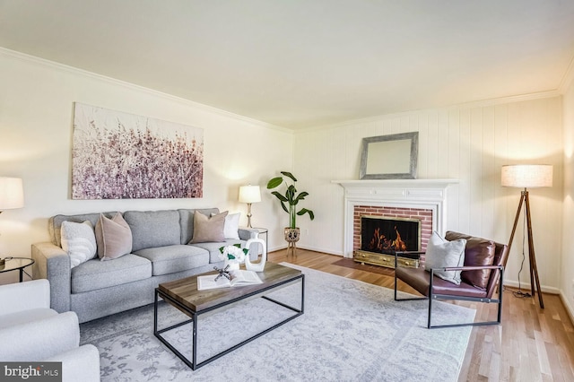 living room featuring ornamental molding, wood-type flooring, and a fireplace