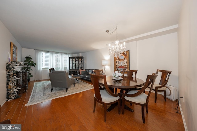 dining space featuring a notable chandelier, hardwood / wood-style flooring, and baseboard heating