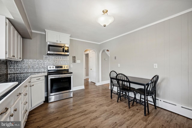 kitchen featuring stainless steel appliances, white cabinetry, backsplash, and dark hardwood / wood-style flooring