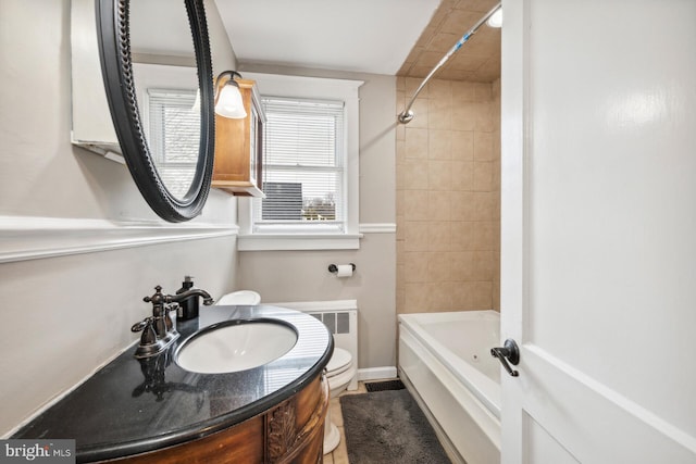 full bathroom with tiled shower / bath, vanity, and toilet