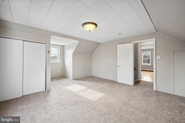 bonus room with lofted ceiling, light colored carpet, and baseboard heating