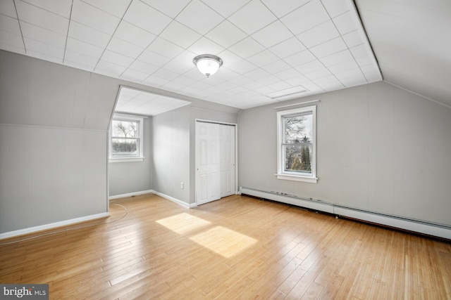 bonus room featuring baseboard heating, vaulted ceiling, and light wood-type flooring