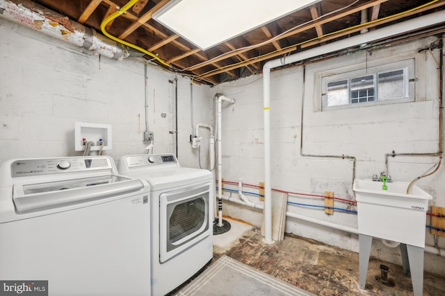 clothes washing area featuring sink and independent washer and dryer