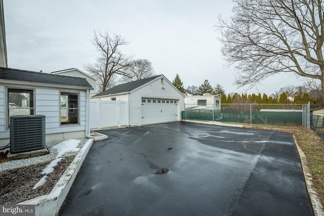 exterior space featuring a garage, an outdoor structure, and central AC unit