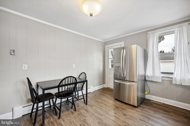 dining area with crown molding and hardwood / wood-style floors