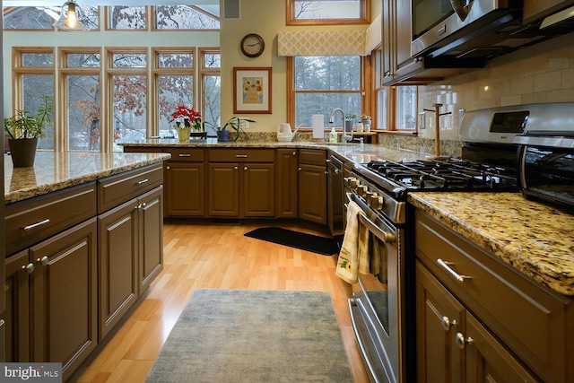 7 Heron Ct, Medford, NJ 08055 - kitchen featuring sink, light stone counters, light hardwood / wood-style flooring, stainless steel range with gas stovetop, and decorative backsplash