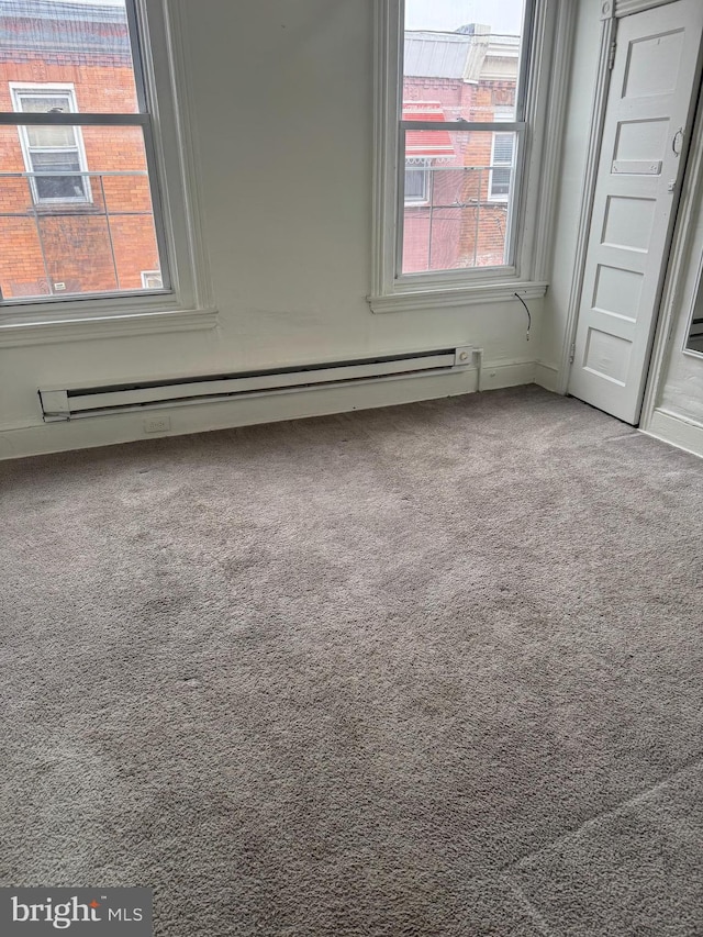 empty room with carpet floors and a baseboard radiator