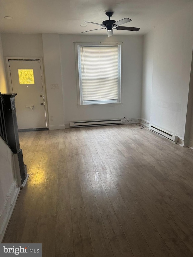 interior space featuring a ceiling fan, a baseboard heating unit, and hardwood / wood-style floors