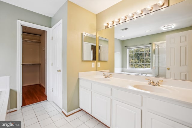 full bath featuring a bath, tile patterned flooring, a sink, and visible vents