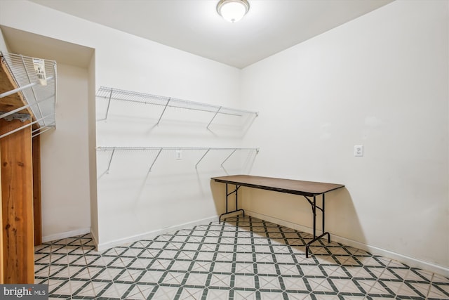 walk in closet with light floors