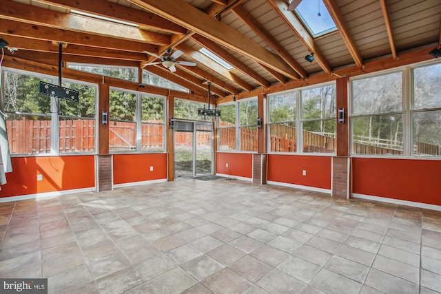 unfurnished sunroom featuring vaulted ceiling with skylight, plenty of natural light, and a ceiling fan