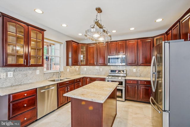 kitchen featuring reddish brown cabinets, stainless steel appliances, recessed lighting, decorative backsplash, and a sink