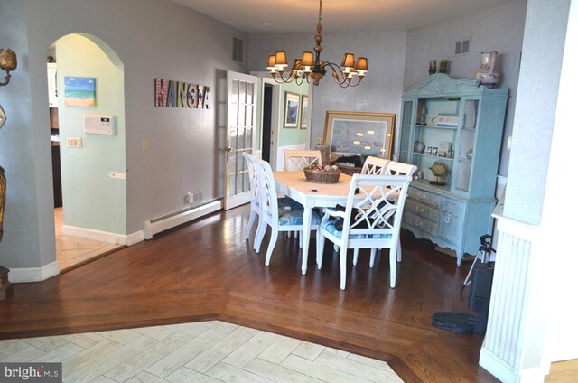 dining area with a baseboard heating unit, parquet floors, and a chandelier