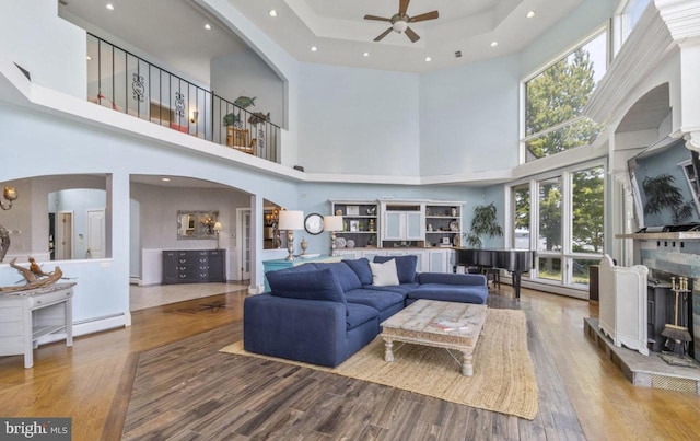 living room featuring ceiling fan, a tray ceiling, and hardwood / wood-style floors