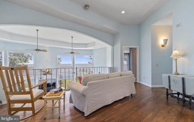 living room featuring a raised ceiling and dark hardwood / wood-style floors