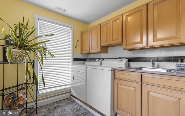 washroom with sink, cabinets, and washer and dryer