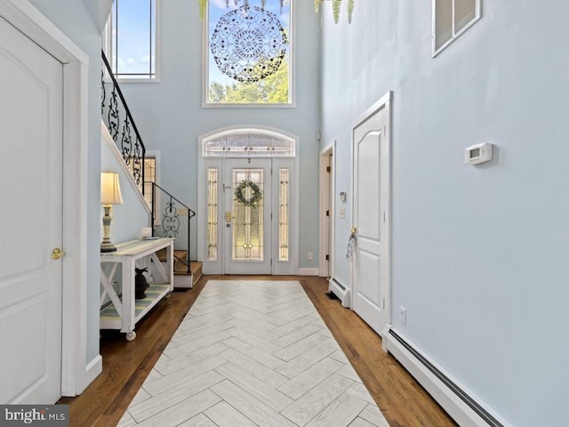 entryway featuring wood-type flooring, a healthy amount of sunlight, and baseboard heating