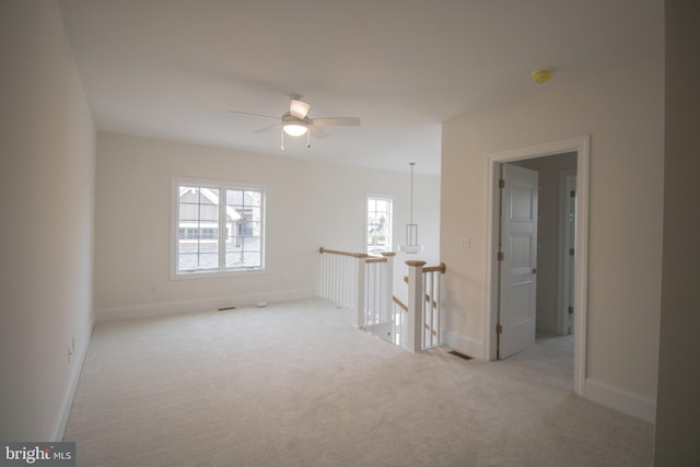 carpeted empty room featuring ceiling fan